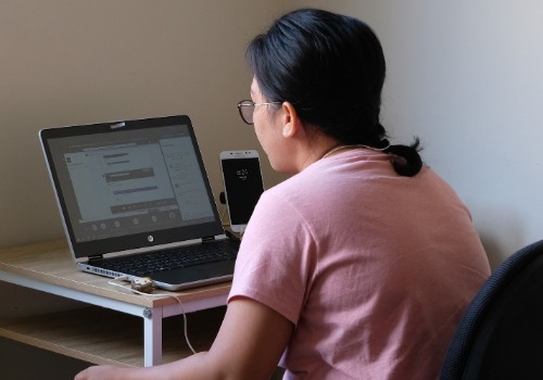 A woman working remotely from her home working set-up